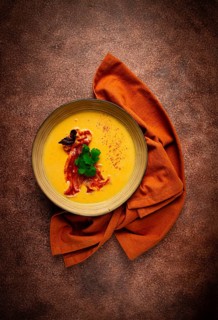 Pumpkin cream soup, curry, fried bacon, bruschetta chips, micro-greens, top view, no people