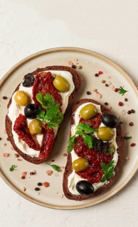 Breakfast, sandwiches with dried tomatoes, olives, and cheese cream, top view