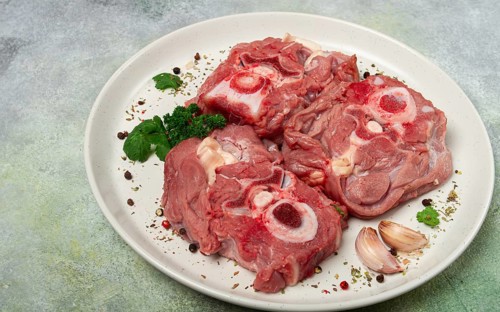 Raw steak, calf's neck on the bone, fresh meat, on a white plate, top view, no people