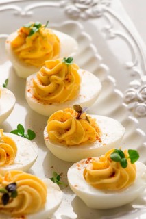 Boiled eggs stuffed with yolk with mayonnaise, on a white plate, selective focus, blurry, close-up,