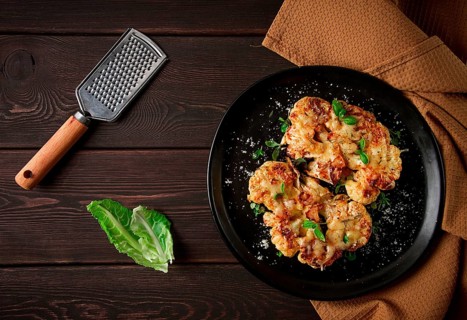 Steak, cauliflower, with cheese, spices, homemade, on a wooden table, dark background, close-up,