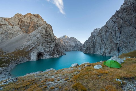 Wild camping, camping in the wilderness with a tent in front of mountain lake Kol Suu, Sary Beles