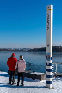 Winter in the Ruhr area, Lake Baldeney, snow-covered, partly frozen lake, shore, pier Strandbad,
