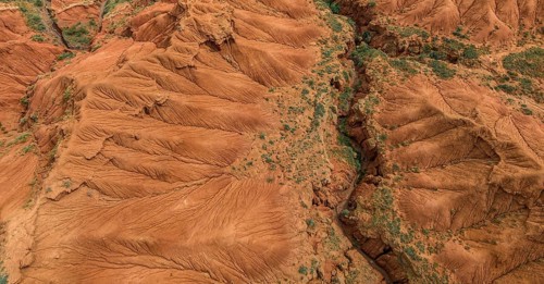 Eroded mountain landscape, top-down, canyon with red and orange rock formations, aerial view,