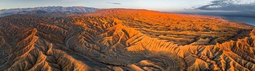 Panorama, river bed runs through a landscape of eroded hills at Lake Issyk Kul, badlands at