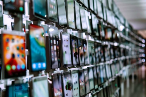 Various used smartphones and mobile phones lined up and fixed to a device. Symbolic image for a