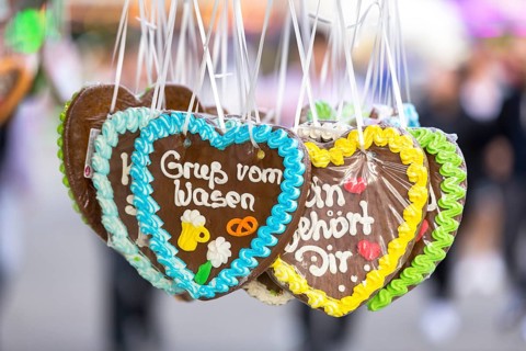 Gingerbread hearts decorated with colourful icing with the inscription 'Gruß vom Wasen',