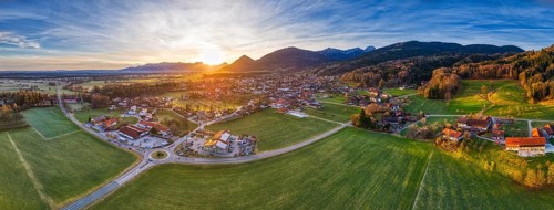 Panoramic view of a wide landscape with a village and mountains in the evening light, Bad Feilnbach