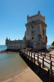 Historic stone tower with bridge over water in sunny weather, Torre de Belém, World Heritage Site,