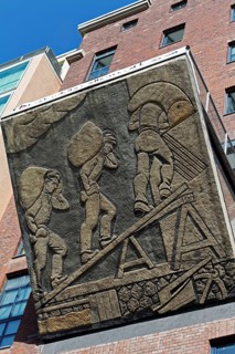 Harbour workers loading sacks of grain, historical relief on the office building Speicher Dock 13,