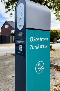 Public e-charging station with inscription "Ökostrom Tankstelle für E-Autos Elektro-Autos an