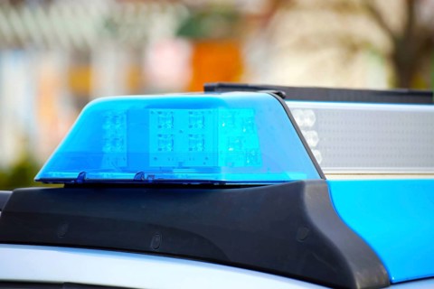 Symbolic image: Close-up of a police car with flashing blue lights