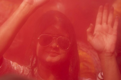 A girl dancing in the beat of music as she celebrate Holi on a street, the Hindu spring festival of