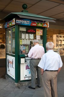 Two men waiting to purchase lottery tickets from a street booth, Seville, Spain, Europe