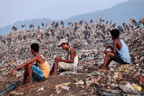 Ragpicker sitting next to a garbage-heap at Boragaon dumping site, on the eve of World Environment