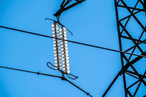 Insulators made of glass on a high-voltage line, they hang on the pylons as a suspension device