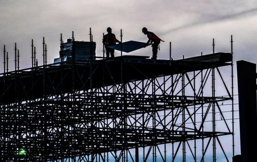 Workers dismantle scaffolding on the Erasmus Bridge over the Nieuwe Maas in Rotterdam, Netherlands