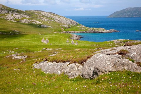 View over machair grassland to abandoned croft houses in the deserted village of Eorasdail,