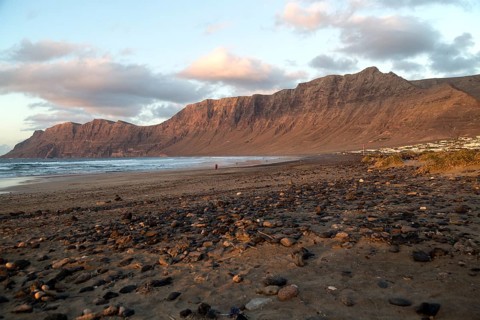 Evening sunset light on beach and cliffs La Caleta de Famara, Lanzarote, Canary islands, Spain,