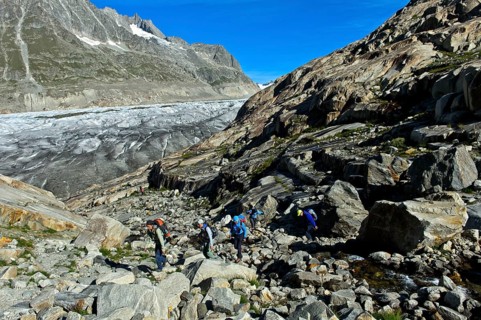 A group of hikers in the scree on the Great Aletsch Glacier, UNESCO World Heritage Swiss Alps