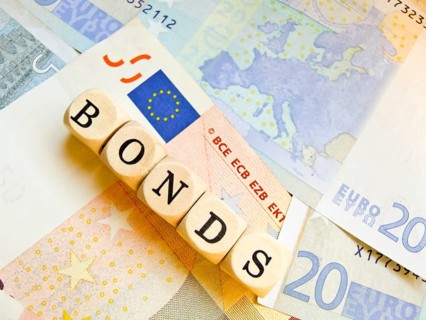 Wooden cube with the inscription 'BONDS' on a background of euro banknotes, outline of the European