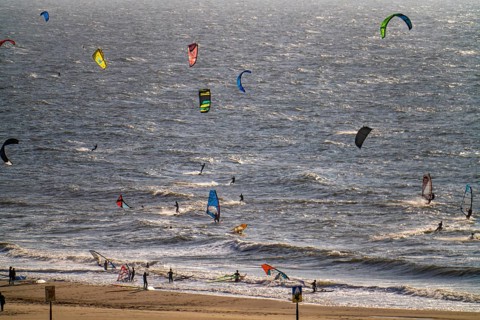 Kitesurfers and windsurfers in strong winds on the beach of Scheveningen, The Hague, Netherlands