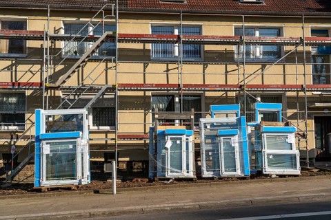 Energy-efficient refurbishment of residential buildings, older apartment block is scaffolded, gets