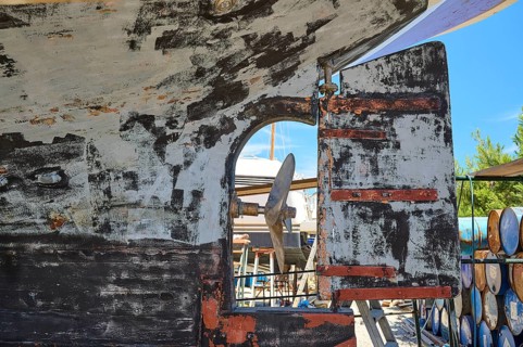 Weathered hull with propeller and defective stern rudder, Patmos Marine, boatyard, Diakofti,