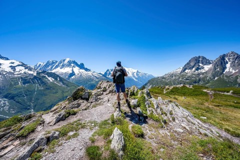 Mountaineer on hiking trail, mountain panorama with glaciated mountain peaks, Aiguille du Midi and