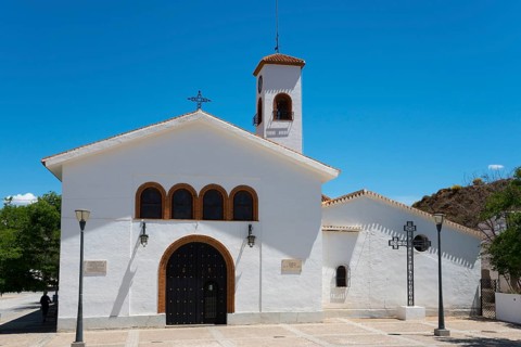 White church with bell tower under a clear blue sky with symbolic religious details, Nuestra Señora