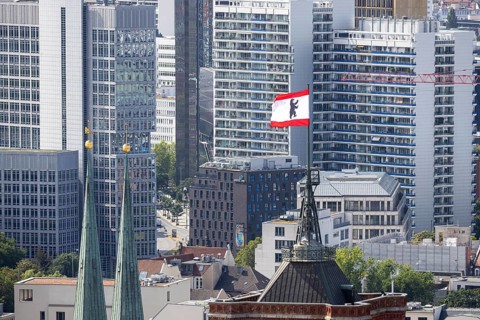 City view. View of the spires of the Rotes Rathaus and the Nikolaikirche. Flag with Berlin bear,