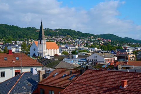 City of Molde with cathedral church and houses as well as mountains and sky in the background,