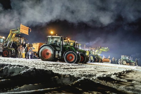 Tractors during a rally as part of the farmers' protests on the snow-covered Kirchbichl,