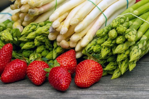 Green asparagus, white asparagus and fresh strawberries decorated on a rustic wooden table