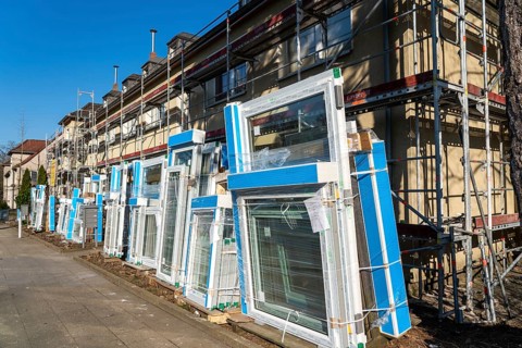 Energy-efficient refurbishment of residential buildings, older apartment block is scaffolded, gets