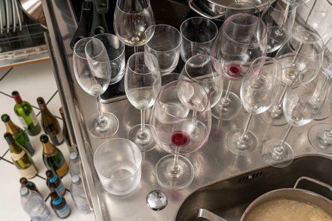 Kitchen after a big dinner, cooking party, dishes, dirty glasses, cooking utensils on the sink,
