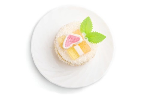 Decorated cake with milk and coconut cream isolated on white background. Side view, close up