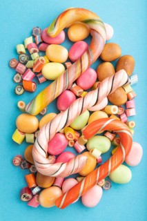 Various caramel candies on blue pastel background. close up, top view, flat lay
