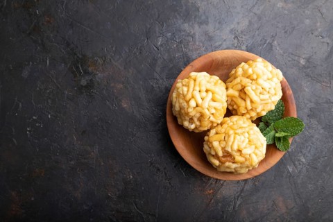 Traditional Tatar candy chak-chak made of dough and honey in wooden plate on a black concrete
