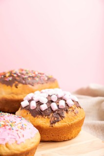 Homemade glazed and decorated easter pies with chocolate eggs and rabbits on a gray and pink