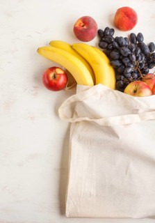 Fruits in reusable cotton textile white bag. Zero waste shopping, storage and recycling concept,