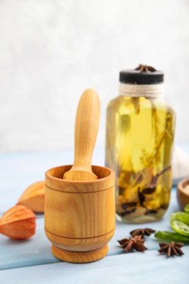 Sunflower oil in a glass jar with various herbs and spices, sesame, rosemary, star anise, basil on