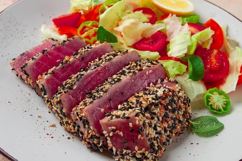 Fillet of red tuna meat, fried in sesame seeds, homemade, close-up, no people, on a wooden