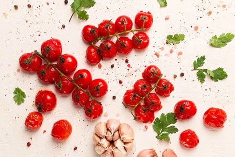 Baked branch, mini, cherry tomatoes, with spices and herbs, garlic, food background, top view, on a