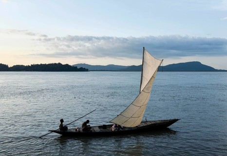 Fishermen paddle down the Brahmaputra River after fish in Guwahati, Assam, India on August 25, 2019