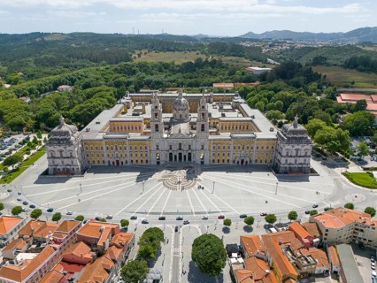 Aerial view of a historic palace in baroque style, surrounded by green vegetation and old building