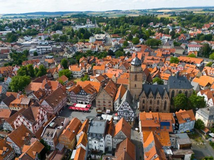 Aerial view of a picturesque historic town centre with many half-timbered houses and a large