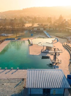 Winter sunrise over a quiet swimming pool with slide and frost-covered roof, ENCW outdoor pool