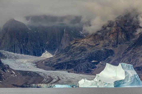 Large icebergs in fjord in front of steep mountains, glacier tongue, cloudy mood, summer, Scoresby