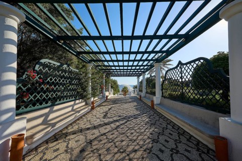Covered walkway with pergola and geometric patterns, cast shade and view of nature, thermal